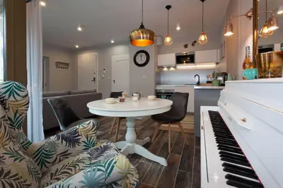 a kitchen and living room with a table and a piano at City of The Kings Piano Apartment in Kraków