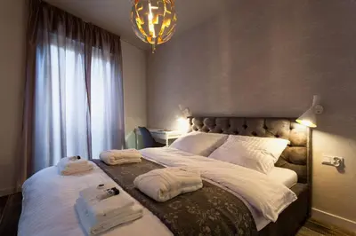 a bedroom with a large bed with towels on it at City of The Kings Piano Apartment in Kraków