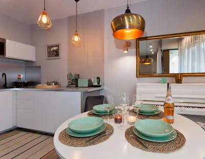 a kitchen with a table with plates and glasses on it at City of The Kings Piano Apartment in Kraków