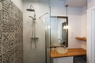 a bathroom with a shower and a sink and a mirror at City of The Kings Piano Apartment in Kraków