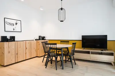 a dining room with a table and a flat screen tv at Colors Apartments Zator - tylko 10 minut piechotą od Energylandii in Zator