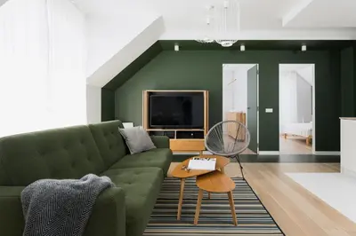 a living room with a green couch and a tv at Colors Apartments Zator - tylko 10 minut piechotą od Energylandii in Zator