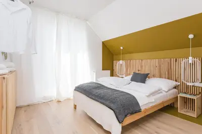 a bedroom with a bed with a green accent wall at Colors Apartments Zator - tylko 10 minut piechotą od Energylandii in Zator