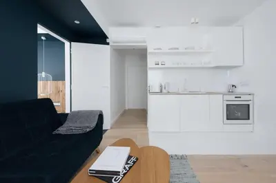 a living room with a black couch and a table at Colors Apartments Zator - tylko 10 minut piechotą od Energylandii in Zator
