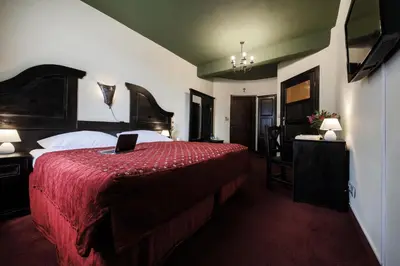 a bedroom with a bed with a laptop on it at Hotel Kasztel in Rzezawa