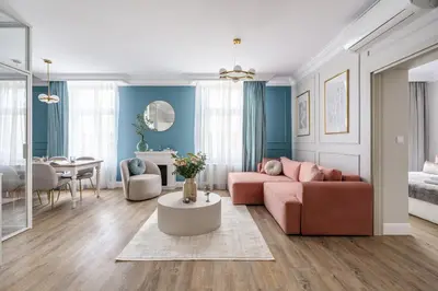 a living room with a pink couch and a table at District17 by StayLab in Kraków