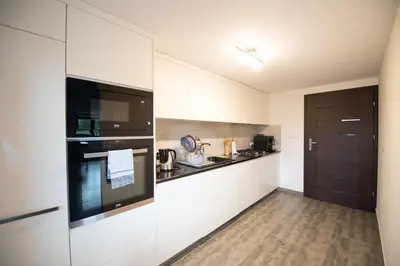 a kitchen with white cabinets and a black oven at u Jagody in Mszana Dolna