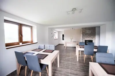 a dining room with a table and blue chairs at u Jagody in Mszana Dolna