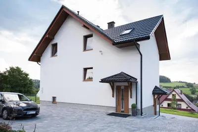 a white house with a black roof at u Jagody in Mszana Dolna