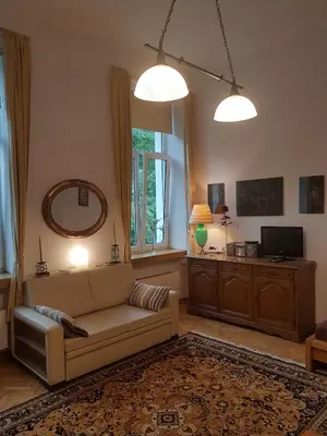 a living room with a couch and a mirror at Leonardo in Kraków