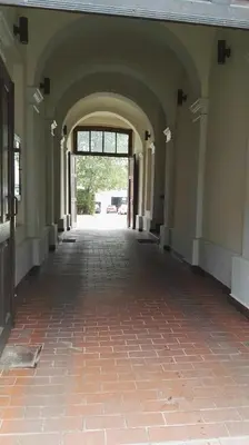 an empty hallway of a building with a brick floor at Leonardo in Kraków