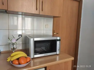 a microwave and a bowl of fruit on a counter at Your trip apartment (1) in Kraków