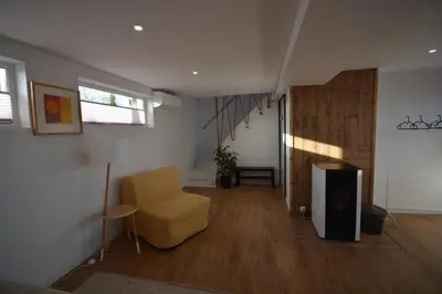 a living room with a chair and a television at LendHouse - SPA pod Gwiazdami in Sąspów