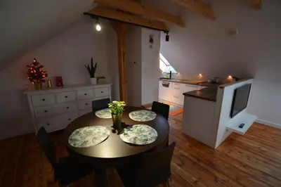a kitchen with a table with chairs and a television at LendHouse - SPA pod Gwiazdami in Sąspów