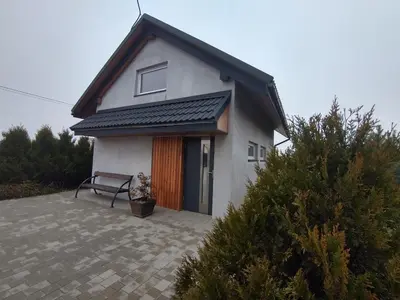 a small white house with a bench in front of it at LendHouse - SPA pod Gwiazdami in Sąspów