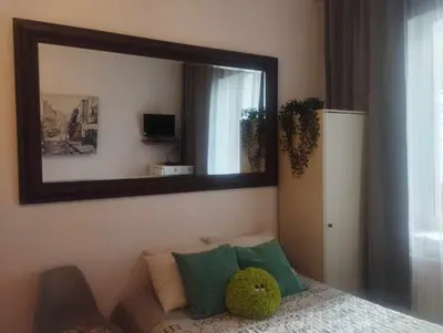 a mirror on a wall with a couch in a room at Your trip apartment (2) in Kraków