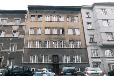 a tall building with cars parked in front of it at Your trip apartment (2) in Kraków
