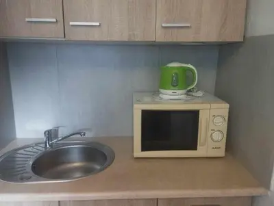 a microwave with a green mug on top of it at Your trip apartment (2) in Kraków