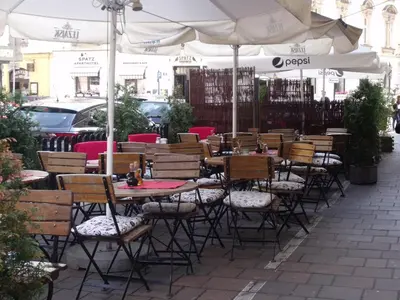 a row of tables and chairs under an umbrella at Your trip apartment (2) in Kraków