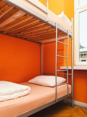 two bunk beds in a room with an orange wall at LazeMaze Hostel in Kraków