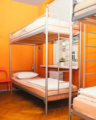 two bunk beds in a room with a yellow wall at LazeMaze Hostel in Kraków