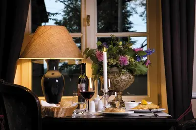 a table with a candle and a vase of flowers at Dwór Sieraków in Sieraków