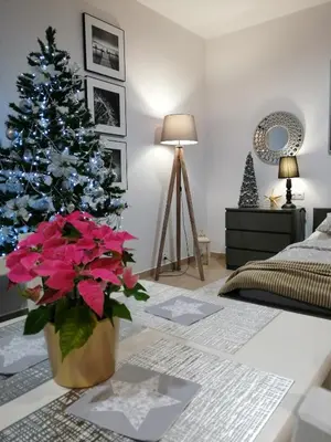 a living room with a christmas tree and a vase of flowers at Apartament Rondo in Trzebinia