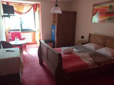 a bedroom with a bed and a table and a window at Zajazd pod Chmurką in Rabka