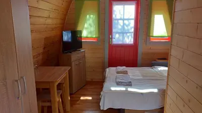 a small room with a bed and a television at Zajazd pod Chmurką in Rabka