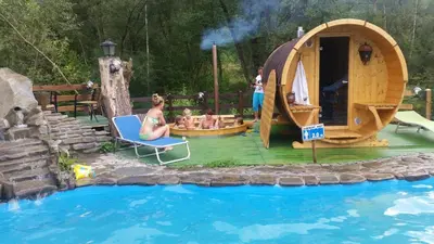 a group of people sitting on a deck next to a pool at Zajazd pod Chmurką in Rabka
