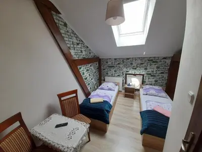 a attic room with two beds and a table at Green Hostel in Kraków