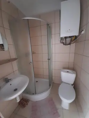 a bathroom with a shower and a toilet and a sink at Green Hostel in Kraków