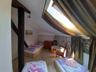 a attic room with two beds and a table at Green Hostel in Kraków