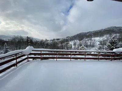 a fence covered in snow next to a mountain at Dom do wynajęcia 