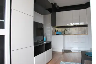 a white kitchen with black and white cabinets at Margaret Apartments in Kraków