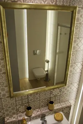 a bathroom mirror with a sink and a toilet at Margaret Apartments in Kraków