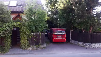 a red truck parked in front of a fence at KrakowHouse in Libertów