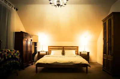 a bedroom with a bed with two night stands and two lamps at KrakowHouse in Libertów