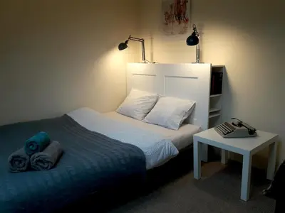 a small bedroom with a bed and a table at KrakowHouse in Libertów