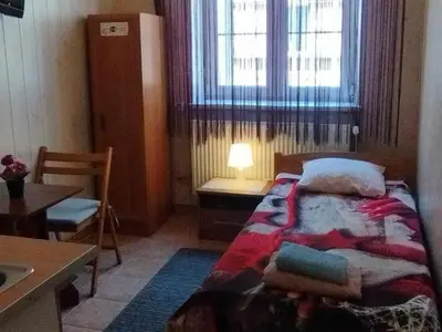 a bedroom with a bed and a table and a window at Apartment for guests (1) in Kraków