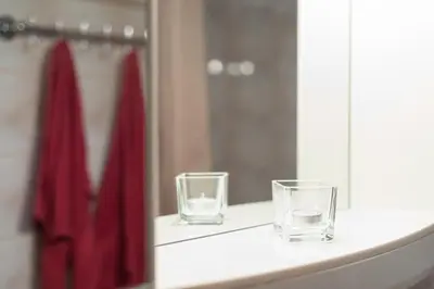 two glasses sitting on a counter in front of a mirror at Apartment for guests (1) in Kraków