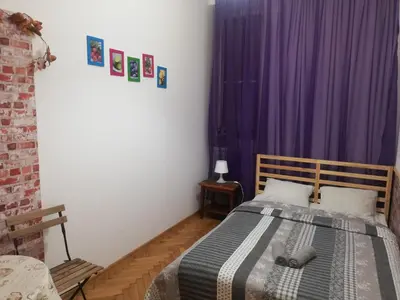 a bedroom with a bed with a purple curtain at Lorf Hostel&Apartments in Kraków