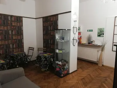 a living room with several shelves of books at Lorf Hostel&Apartments in Kraków