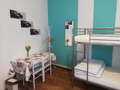 a room with two bunk beds and a table at Lorf Hostel&Apartments in Kraków