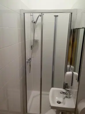 a bathroom with a shower and a sink at Lorf Hostel&Apartments in Kraków