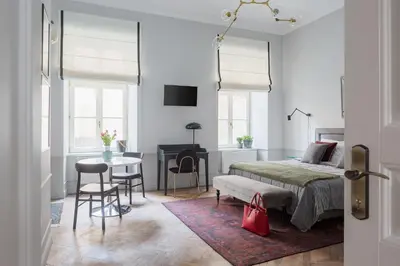a white bedroom with a bed and a table and chairs at Jana 3 Apartments in Kraków