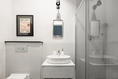 a white bathroom with a sink and a shower at Jana 3 Apartments in Kraków
