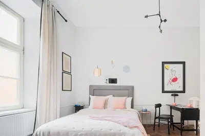 a white bedroom with a bed and a desk at Jana 3 Apartments in Kraków