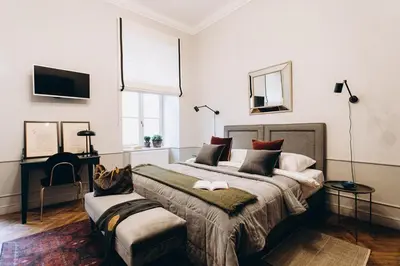 a bedroom with a large bed and a chair at Jana 3 Apartments in Kraków