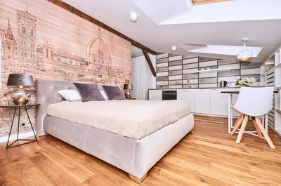 a bedroom with a large bed and a brick wall at Chodkiewicza 10 (A) - cozy studio by Homeprime in Kraków